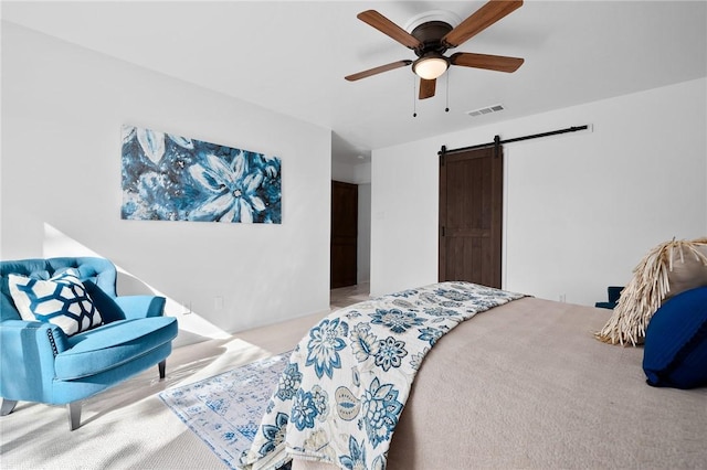 carpeted bedroom with a barn door, ceiling fan, and a closet