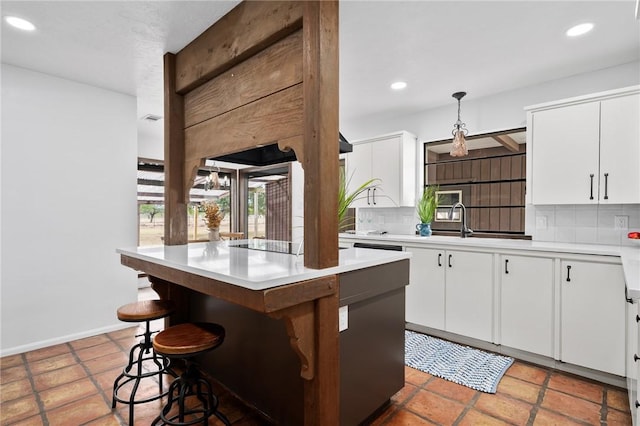 kitchen featuring decorative backsplash, a kitchen breakfast bar, white cabinets, and a kitchen island