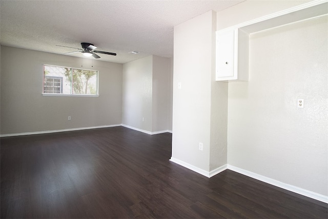 unfurnished room with baseboards, ceiling fan, and dark wood-type flooring