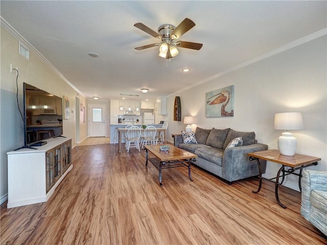 800 Beach Access Road 1a 509, Port Aransas, TX 78373 - living room featuring crown molding, ceiling fan, light wood-type flooring, and baseboards