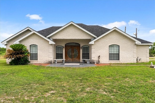 view of front facade featuring brick siding, a front lawn, and a shingled roof