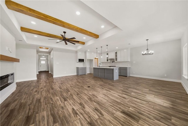 6218 Sadie St, Corpus Christi, TX 78415 - unfurnished living room featuring a chandelier, dark wood-style floors, a large fireplace, recessed lighting, and a raised ceiling