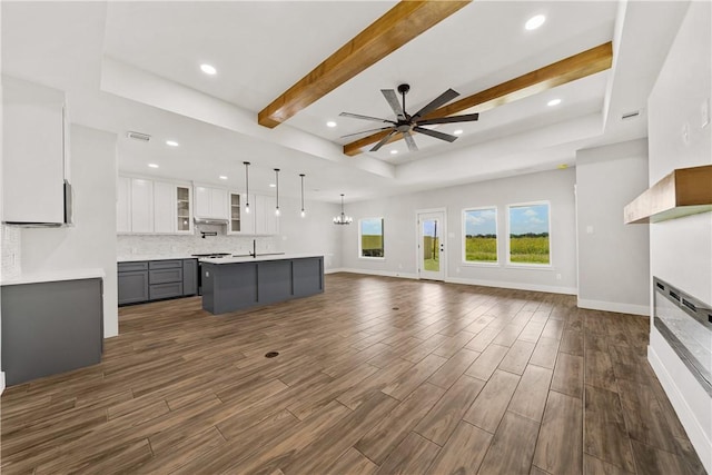 6218 Sadie St, Corpus Christi, TX 78415 - unfurnished living room featuring a ceiling fan, dark wood-type flooring, recessed lighting, a glass covered fireplace, and beam ceiling