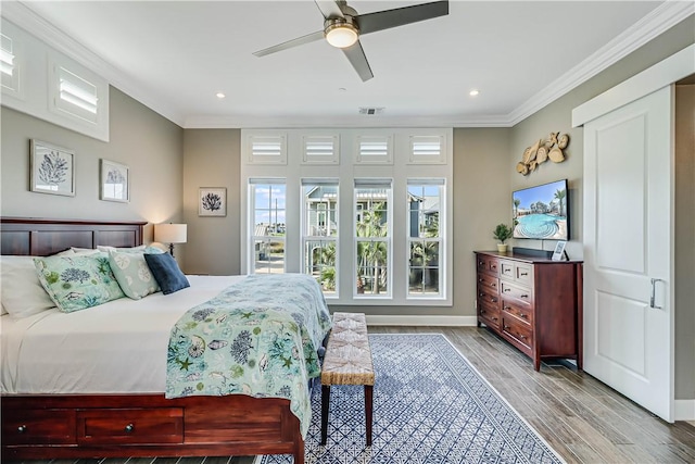 bedroom with ceiling fan, crown molding, and light hardwood / wood-style flooring