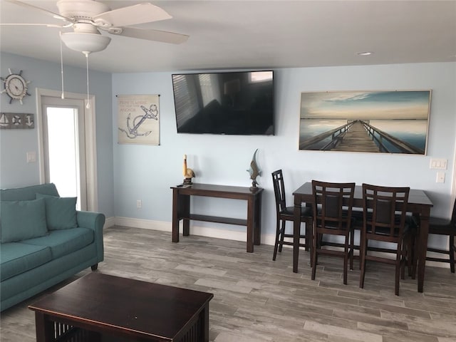 living room featuring ceiling fan and hardwood / wood-style flooring