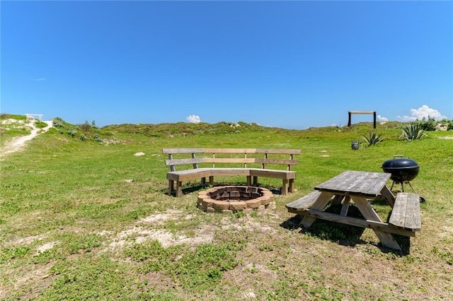 view of home's community with a lawn and an outdoor fire pit