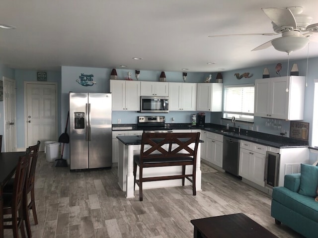 kitchen featuring white cabinets, wood-type flooring, and appliances with stainless steel finishes