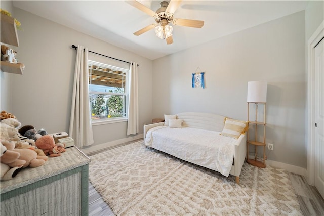 bedroom with a closet, ceiling fan, and baseboards