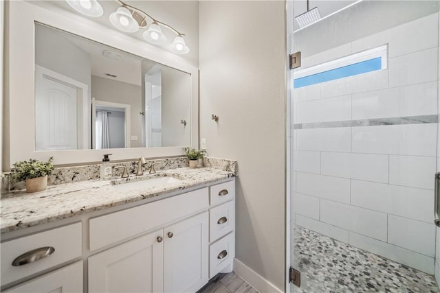 full bath with a stall shower, baseboards, and vanity