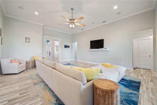 living room with baseboards, light wood-type flooring, a ceiling fan, and crown molding