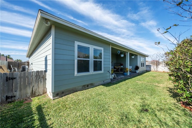 rear view of property with a lawn, a patio, and fence