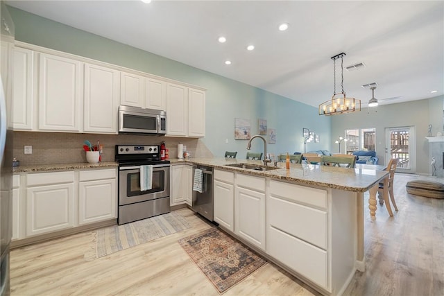 15414 Salt Cay Ct Unit 5E, Corpus Christi, TX 78418 - kitchen featuring a peninsula, a sink, open floor plan, visible vents, and appliances with stainless steel finishes