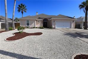 ranch-style home with curved driveway and an attached garage
