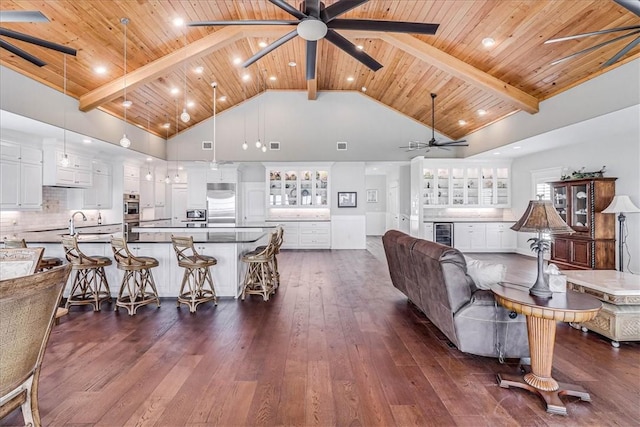 living room with beamed ceiling, dark hardwood / wood-style flooring, high vaulted ceiling, and wooden ceiling