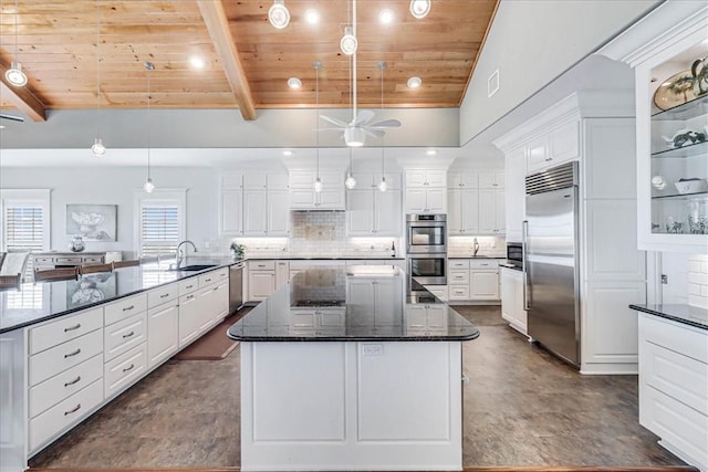 kitchen with tasteful backsplash, dark stone counters, wood ceiling, built in appliances, and decorative light fixtures