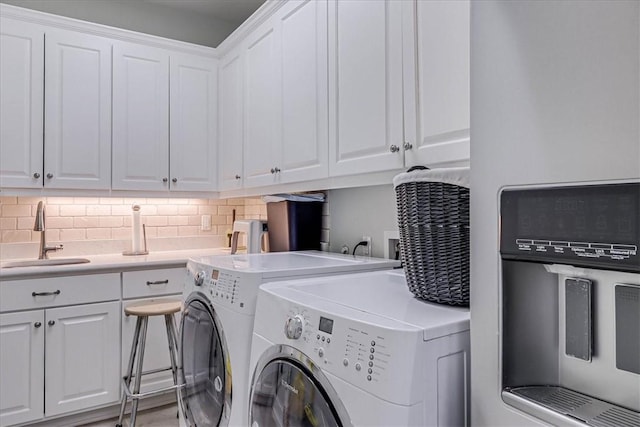 washroom featuring washer and clothes dryer, sink, and cabinets