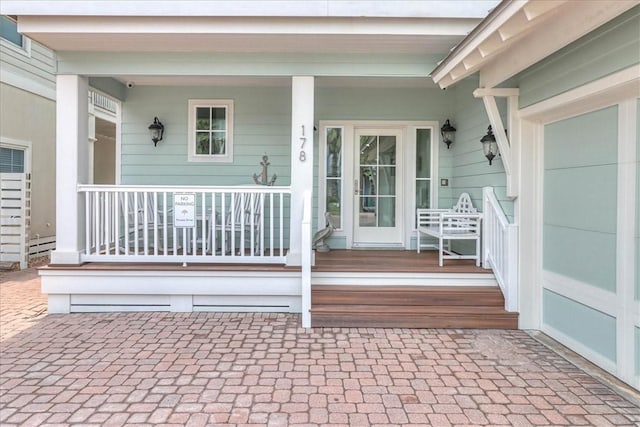 view of exterior entry featuring covered porch