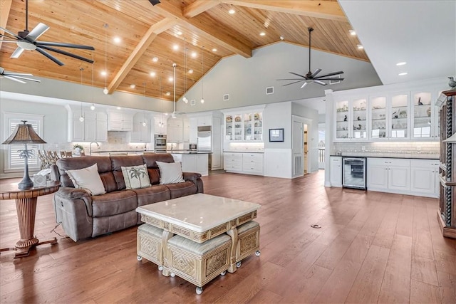 living room featuring beam ceiling, wooden ceiling, beverage cooler, high vaulted ceiling, and dark hardwood / wood-style floors