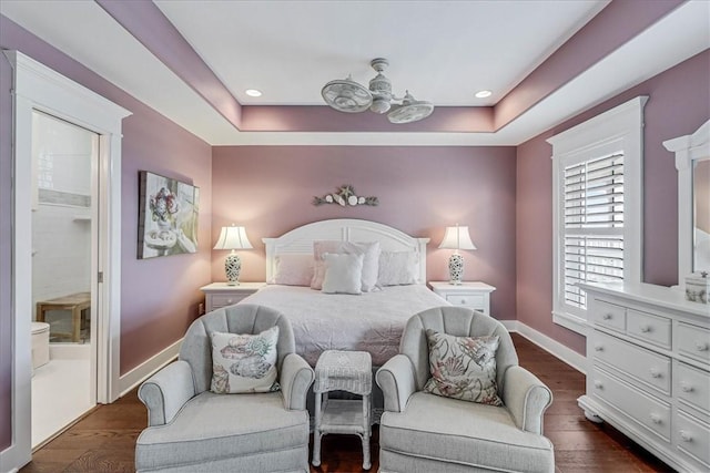 bedroom with a raised ceiling and dark hardwood / wood-style flooring