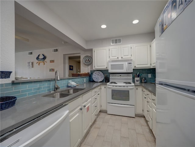 kitchen with white cabinetry, tasteful backsplash, sink, and white appliances