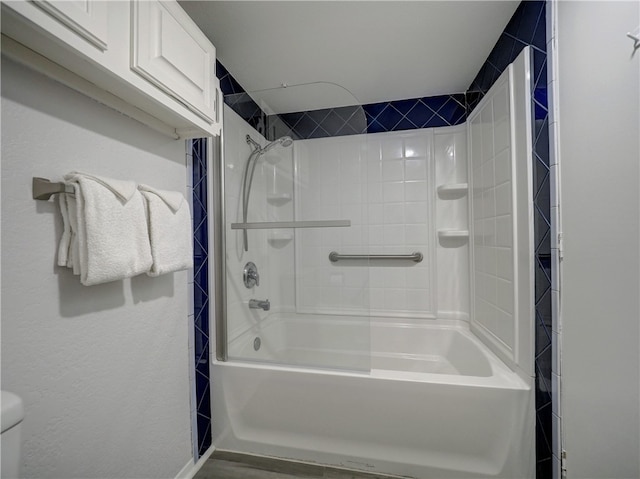 bathroom featuring tiled shower / bath and toilet