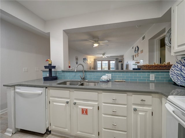 kitchen featuring sink, kitchen peninsula, white appliances, white cabinets, and decorative backsplash