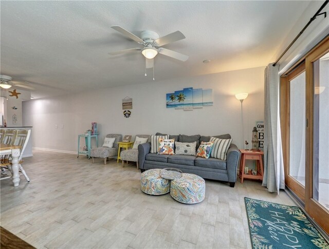 living room with light hardwood / wood-style floors and ceiling fan