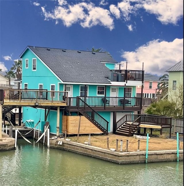 rear view of house featuring a deck with water view and a balcony