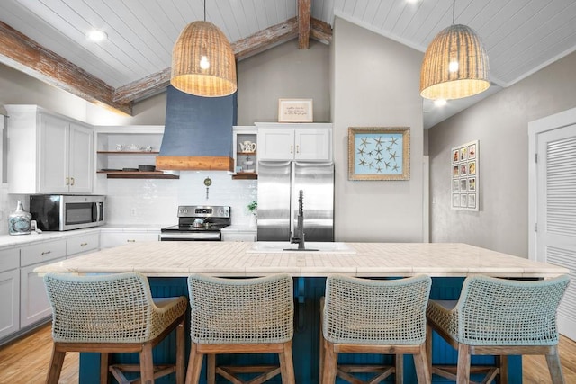 kitchen with extractor fan, stainless steel appliances, light countertops, decorative backsplash, and open shelves