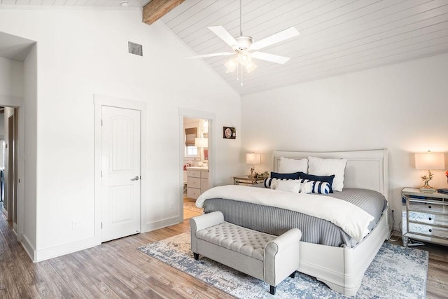 bedroom with baseboards, visible vents, wood finished floors, high vaulted ceiling, and beam ceiling