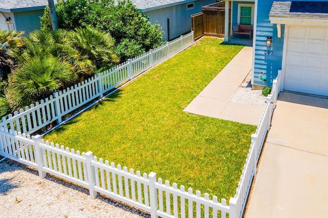 view of yard featuring a garage and fence private yard