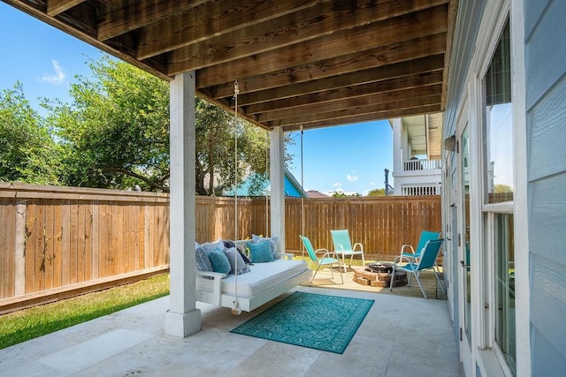 view of patio with an outdoor fire pit and fence