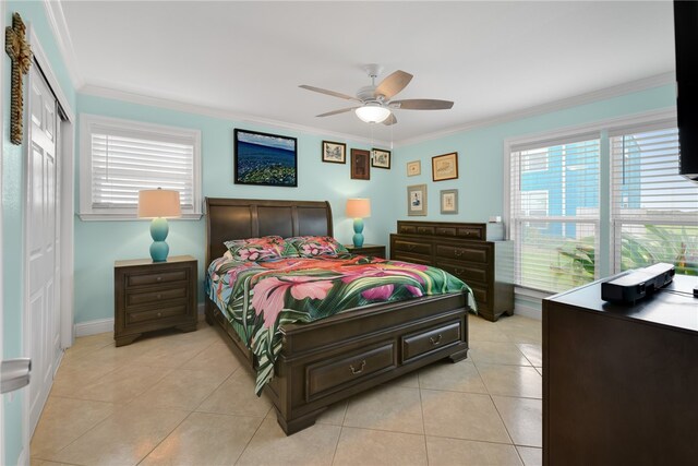 bedroom with light tile patterned floors, ceiling fan, ornamental molding, and a closet