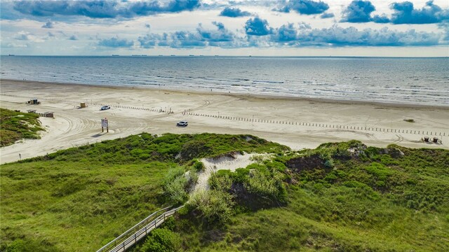 drone / aerial view featuring a water view and a view of the beach