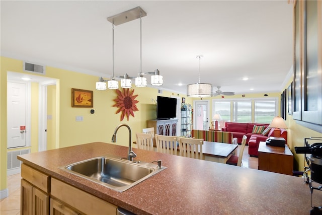 kitchen featuring dark countertops, open floor plan, visible vents, and a sink