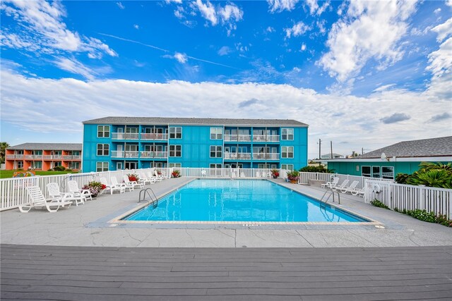 community pool featuring fence and a deck