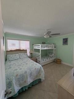 bedroom featuring ornamental molding, tile patterned flooring, a ceiling fan, and baseboards