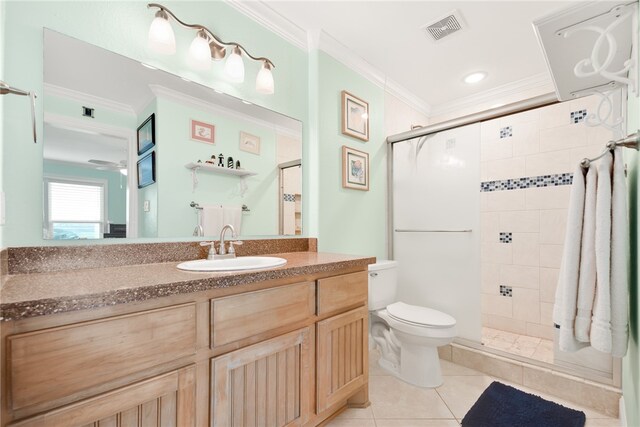 full bath featuring a stall shower, visible vents, toilet, ornamental molding, and tile patterned floors