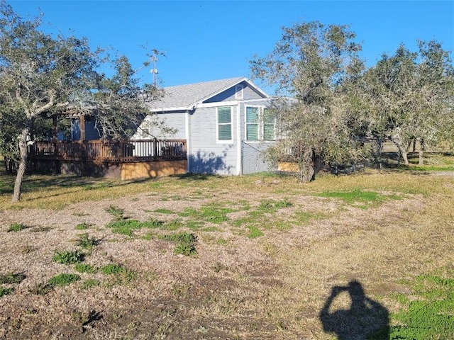 view of side of home featuring a lawn and a wooden deck