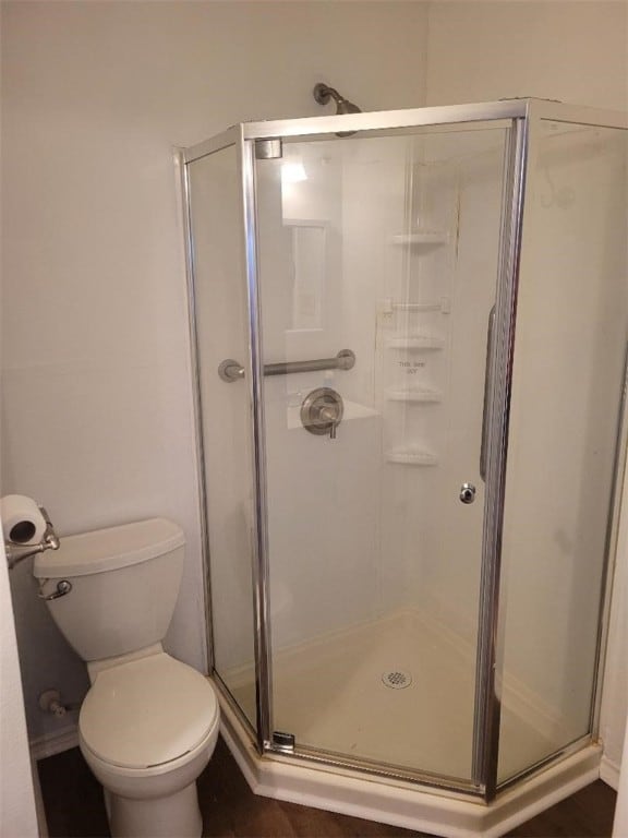 bathroom featuring walk in shower and toilet