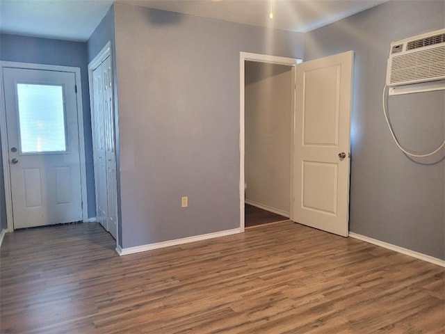 interior space featuring an AC wall unit and hardwood / wood-style flooring