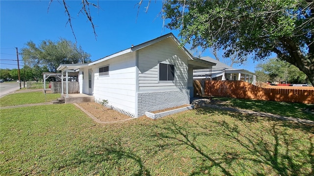 view of side of home with a yard and fence