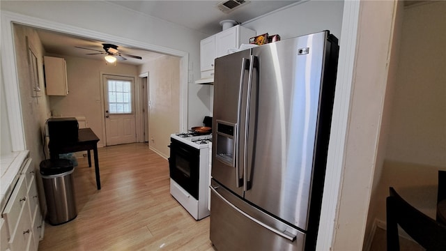 kitchen featuring light wood-type flooring, stainless steel fridge, gas range, visible vents, and ceiling fan