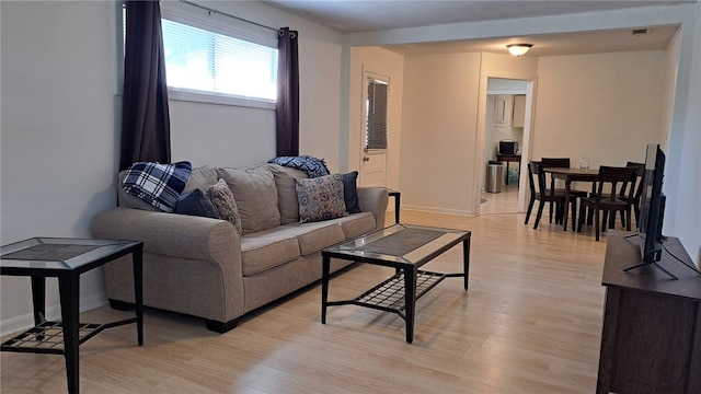living room with baseboards and light wood finished floors