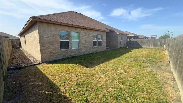 4010 Giants Dr, Corpus Christi, TX 78414 - rear view of house featuring brick siding, a fenced backyard, a lawn, and a shingled roof