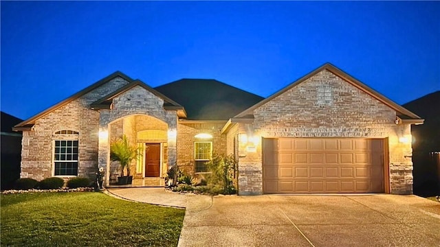 4010 Giants Dr, Corpus Christi, TX 78414 - french provincial home featuring a lawn, stone siding, brick siding, concrete driveway, and an attached garage