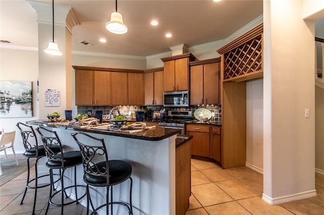 kitchen with pendant lighting, light tile patterned floors, ornamental molding, and stainless steel appliances