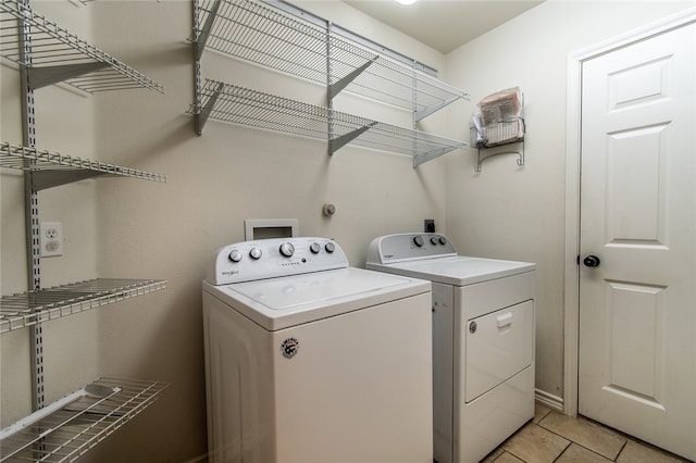 laundry room with washing machine and dryer and light tile patterned floors