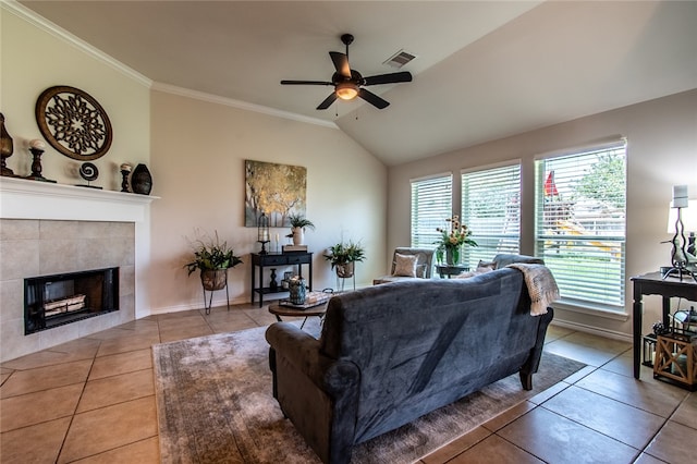 tiled living room with a fireplace, ceiling fan, lofted ceiling, and ornamental molding