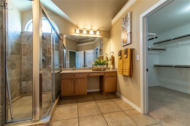 bathroom featuring vanity, a shower with shower door, tile patterned floors, and crown molding